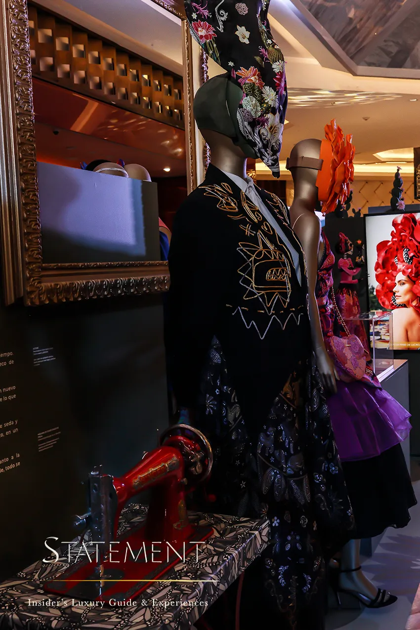Vestido negro con motivos florales y maquina de cocer antigua de la exposición de Pineda Covalin